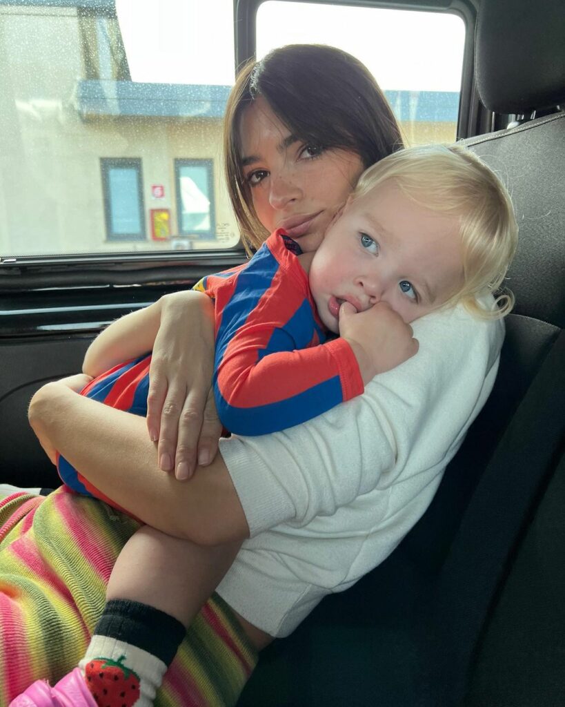Emily Ratajkowski with her child in her car